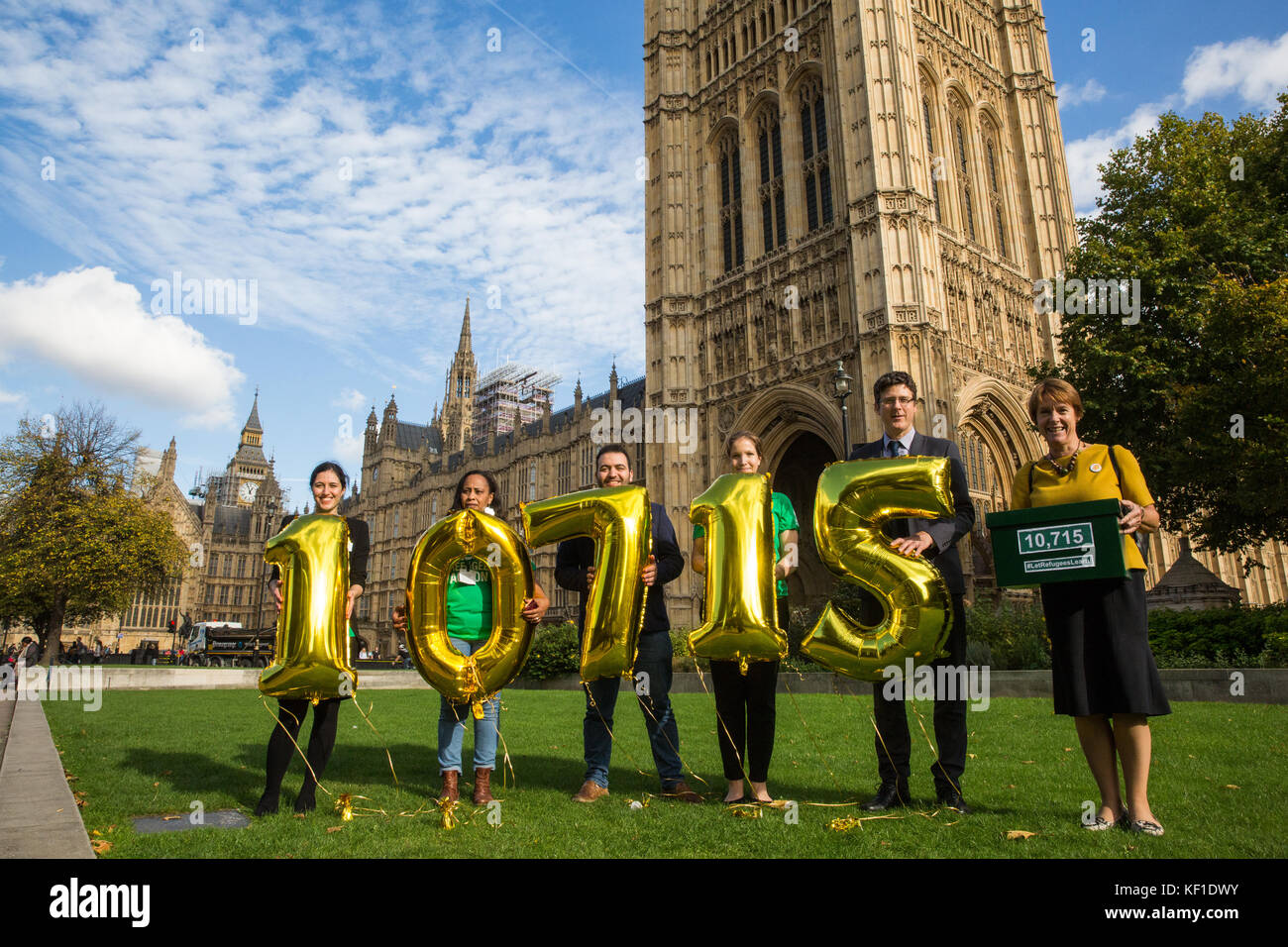 Londra, Regno Unito. 25 ottobre, 2017. dame caroline spelman (r), il conservatore mp per meriden, sorge al di fuori del Parlamento con una petizione al fianco di attivisti dalla azione dei profughi tenendo i numeri che rappresentano i 10,715 persone che hanno firmato la petizione per essere consegnato al 10 di Downing street come parte del "lasciate che i rifugiati imparare" campagna chiedendo al governo di garantire che i rifugiati ottenere un accesso tempestivo alle classi di inglese e il supporto necessari a partecipare alle loro. Credito: mark kerrison/alamy live news Foto Stock