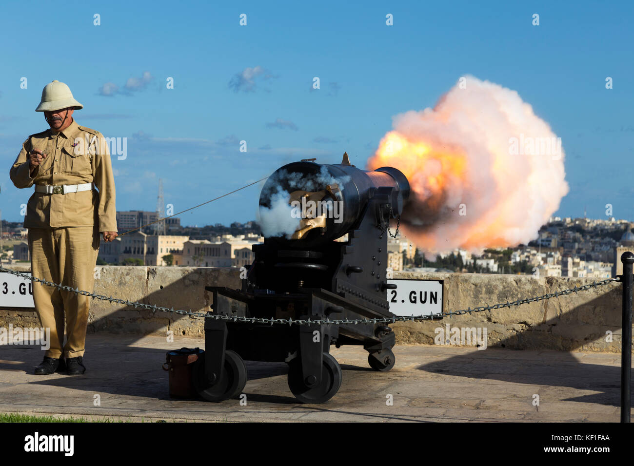 Il numero 2 della pistola la batteria a salve incendi il 4pm segnale orario ed è catturata al momento della detonazione. Il salutando la batteria è una batteria di artiglieria a La Valletta, Malta. Credito: David Gee 4 Foto Stock