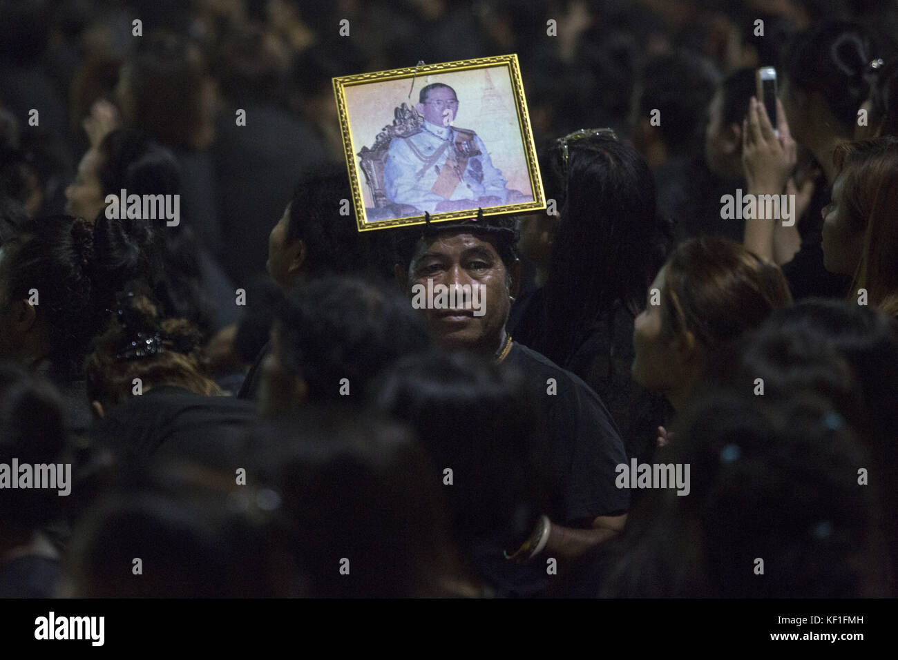 Bangkok, Thailandia. 25 ottobre 2017. Un lutto tailandese tiene una foto del re Bhumibol Adulyadej fuori dal Grand Palace. La cerimonia funebre reale di cinque giorni che ha avuto inizio oggi culminerà il 26 ottobre con la cerimonia di cremazione reale. Centinaia di migliaia di persone partecipano all'evento. Crediti: Alexandra Radu/SOPA/ZUMA Wire/Alamy Live News Foto Stock