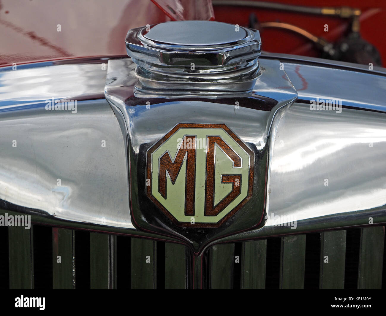Dettaglio della red classic car mostra chrome il tappo del radiatore e smalto MG badge Foto Stock