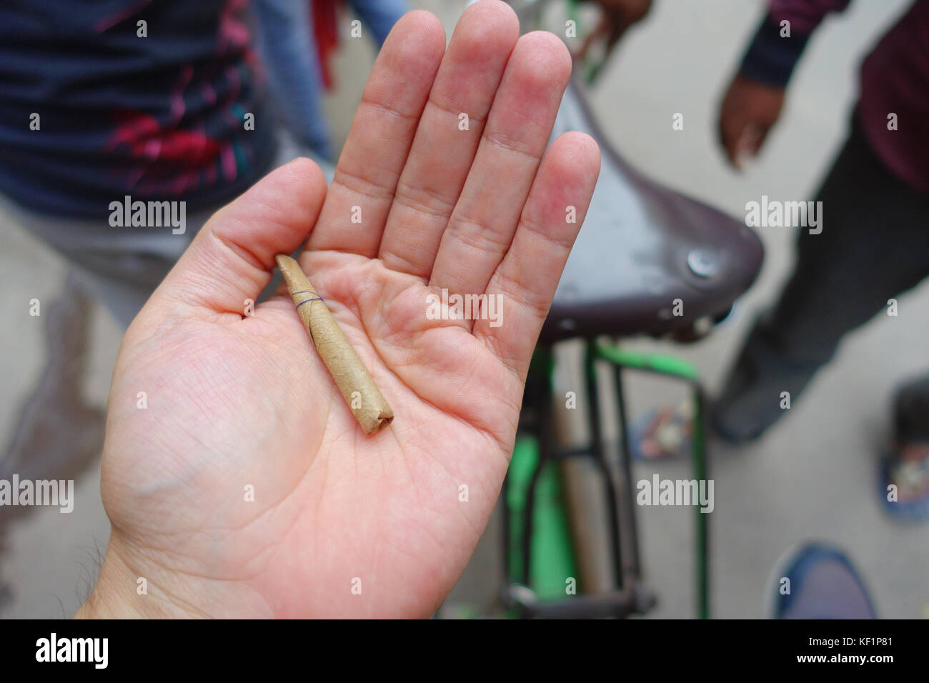 Delhi, India - 25 settembre 2017: close up di una mano di un uomo con una foglia di sigarette incartati a mano, nelle strade di paharganj new delhi india Foto Stock