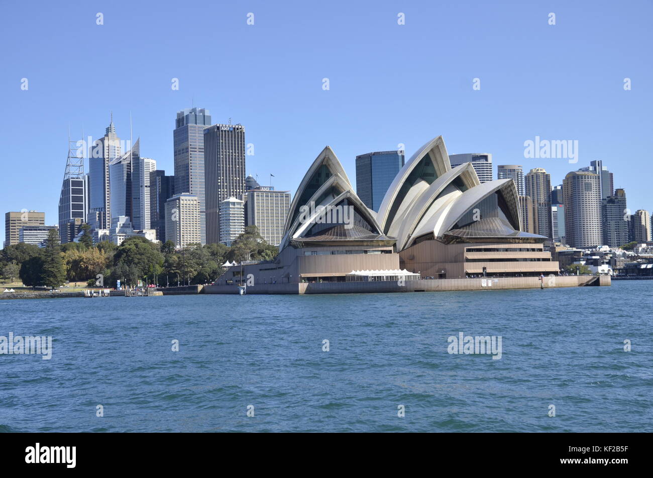 Sydney Opera House at Bennelong Point nel porto di Sydney con la skyline di Sydney dietro Foto Stock