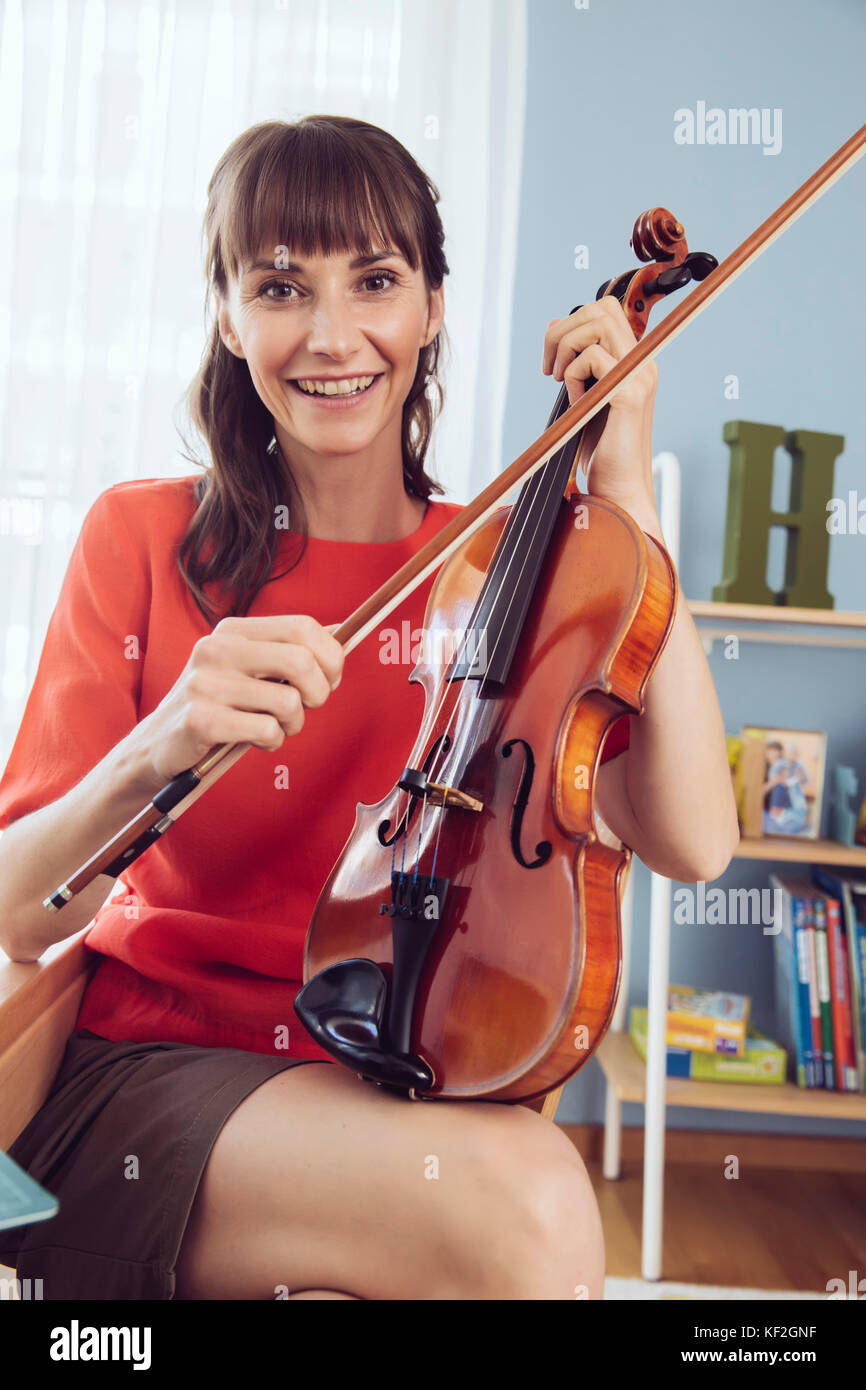 Ritratto di una donna con violino in camera‚Äôs bambini Foto Stock