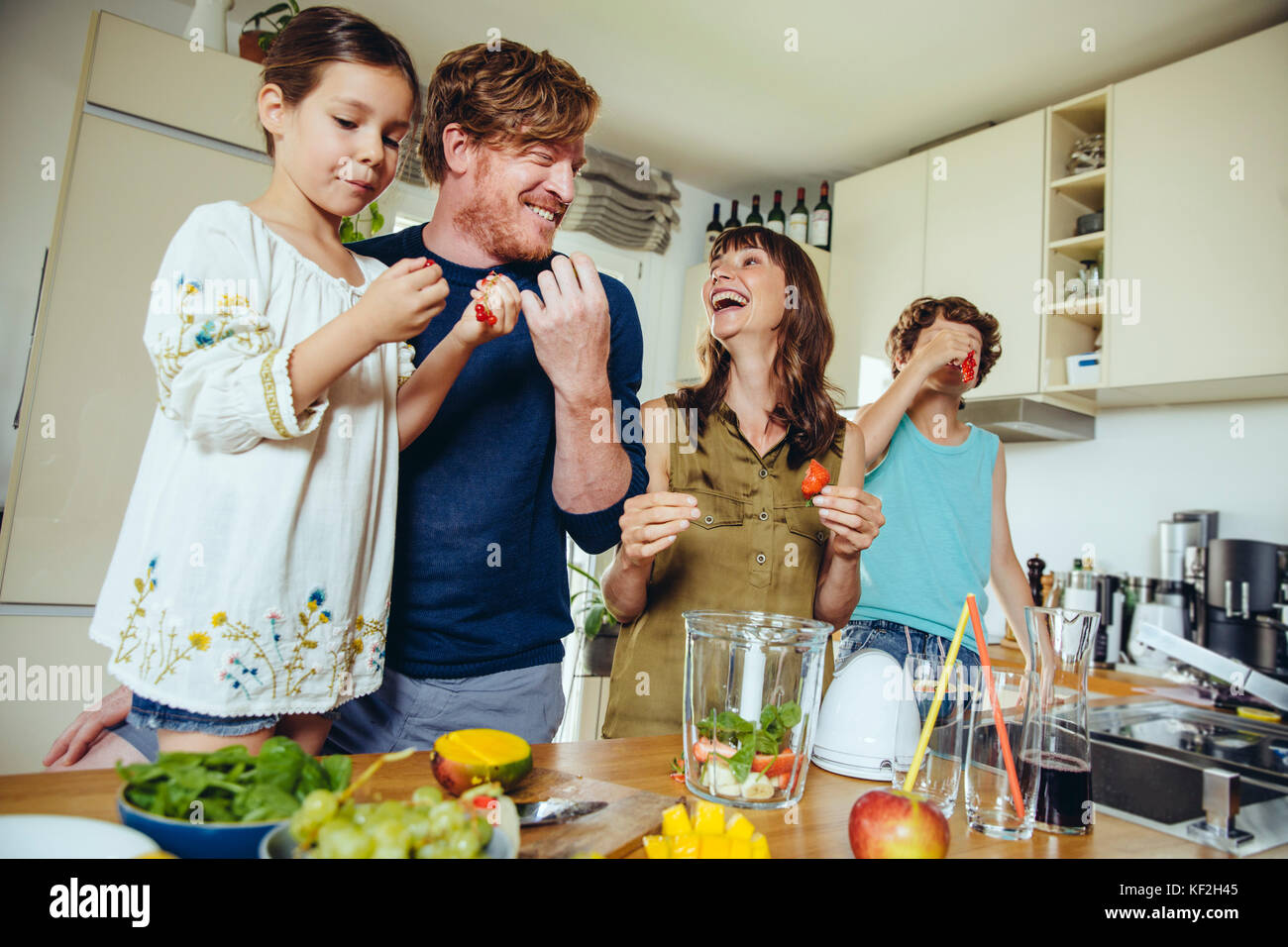 I genitori e i figli frutto di degustazione per un smoothie Foto Stock