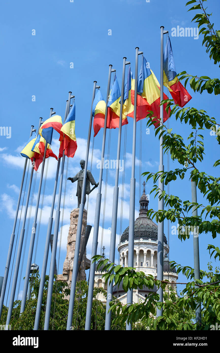 Bandiere svolazzanti nel vento contro il cielo blu con la statua e la Cattedrale Ortodossa in background, Cluj Foto Stock