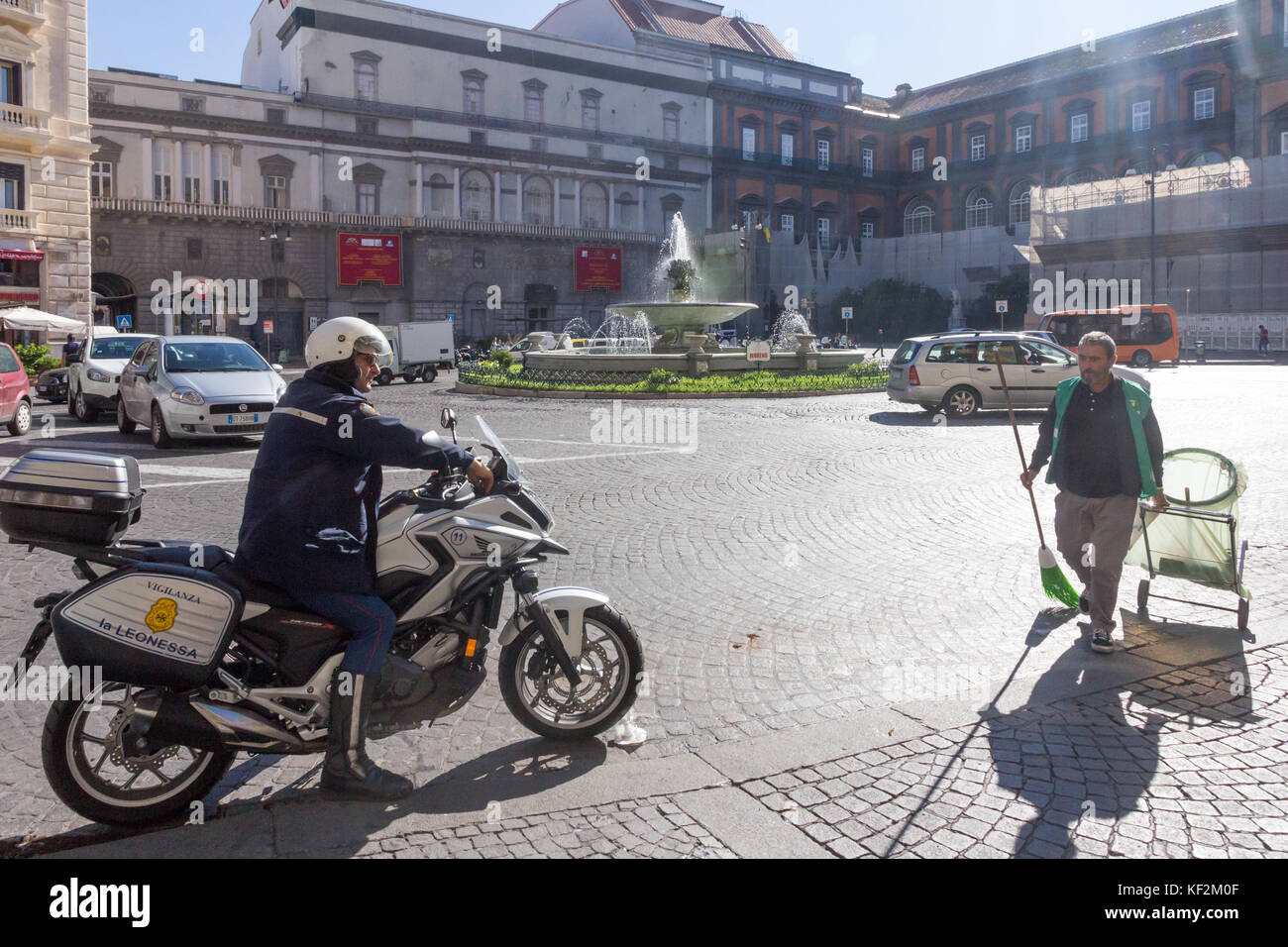 Poliziotto su una moto e roadsweeper nella pizza Trieste e Trento, Napoli, Italia Foto Stock