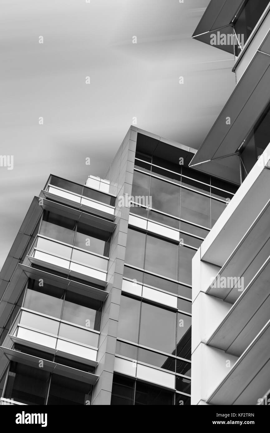 Guardando verso l'alto ufficio moderno edificio contro liscia cielo nuvoloso. alti edifici commerciali. L'architettura finanziaria al Parco olimpico di Sydney, Australia. Foto Stock