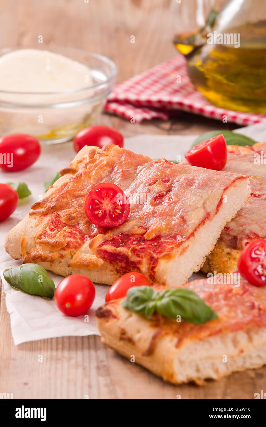 La pizza italiana con formaggio, pomodori e basilico fresco. Foto Stock