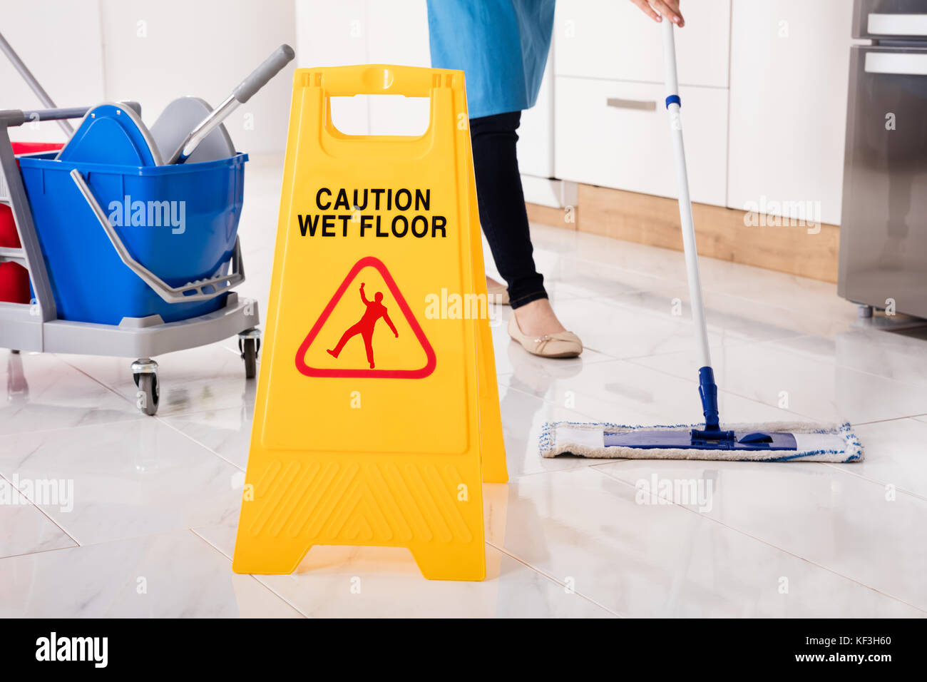 Close-up di umido giallo segno di attenzione sul pavimento bagnato in cucina Foto Stock