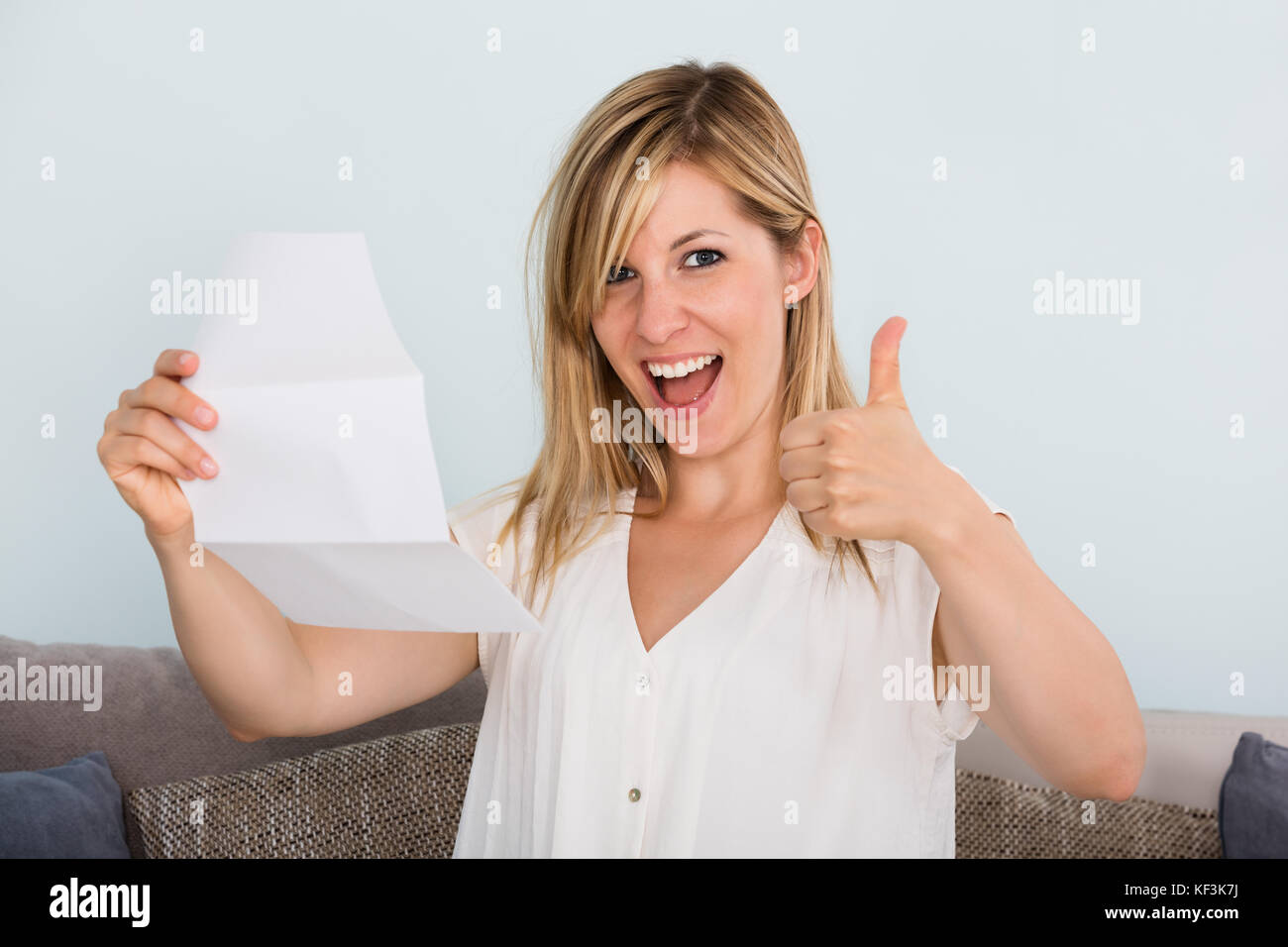 Ritratto di un sorridente giovane donna lettura la lettera Foto Stock