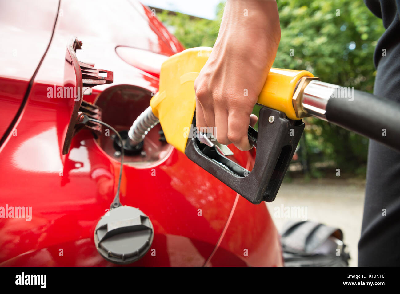 Close-up di imprenditrice la mano il rifornimento auto del serbatoio di contenimento della pompa benzina ugello Foto Stock