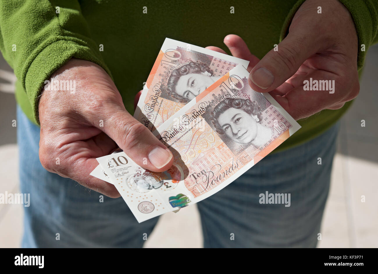Primo piano dell'uomo persona in possesso di contanti banconote da 10 sterline banconote in moneta inglese Inghilterra Regno Unito Gran Bretagna Foto Stock