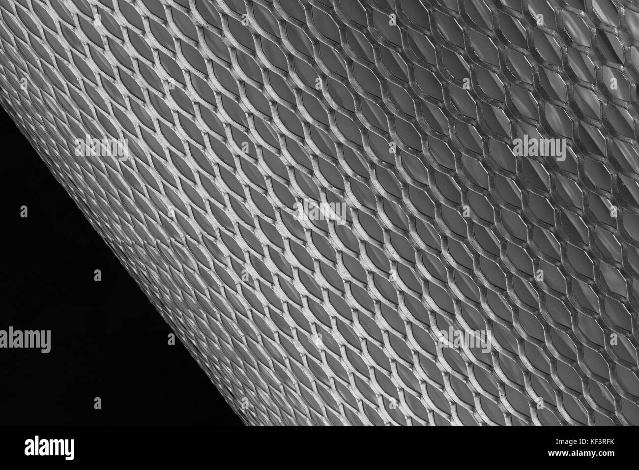 Maglie di metallo per filtro in rotolo su uno sfondo nero Foto Stock