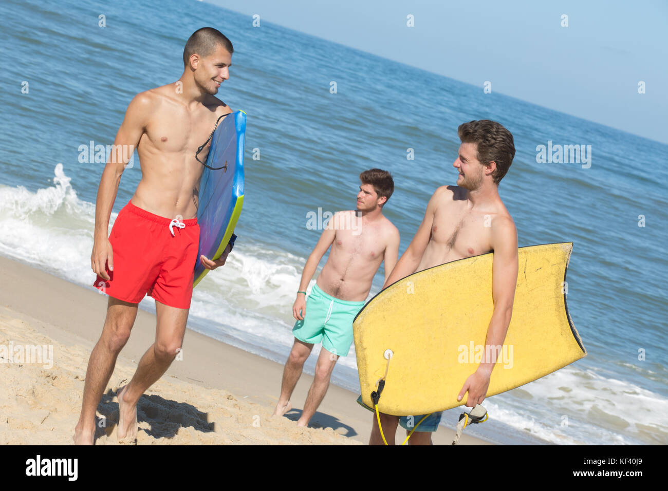 I giovani uomini a beach che trasportano le schede del corpo Foto Stock