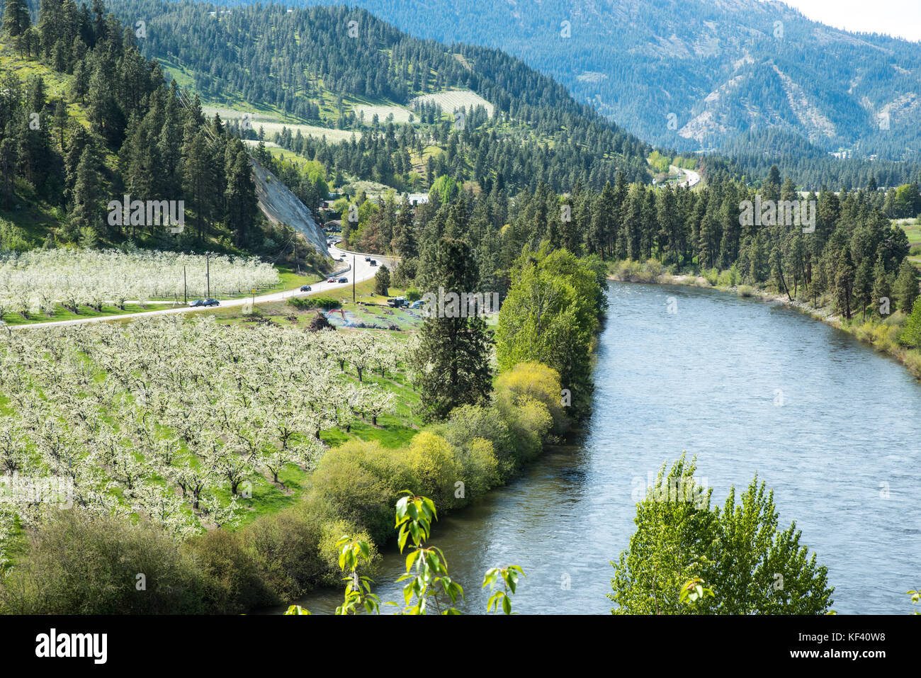 La US Route 2 - US Route 2 parallels il fiume wenatchee, passando frutteti come esso si snoda attraverso il North Cascades range. Foto Stock