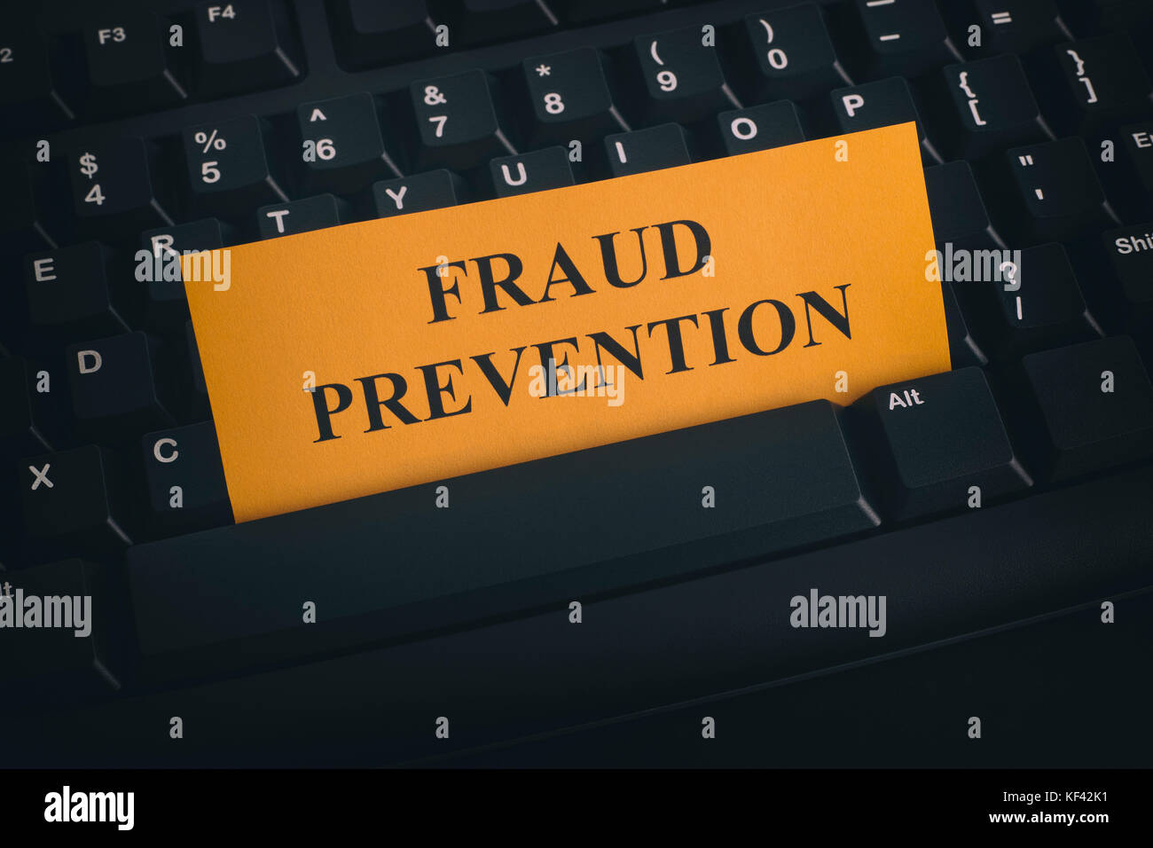 Carta gialla nota sulla tastiera nera con la scrittura della prevenzione delle frodi. close up. Foto Stock