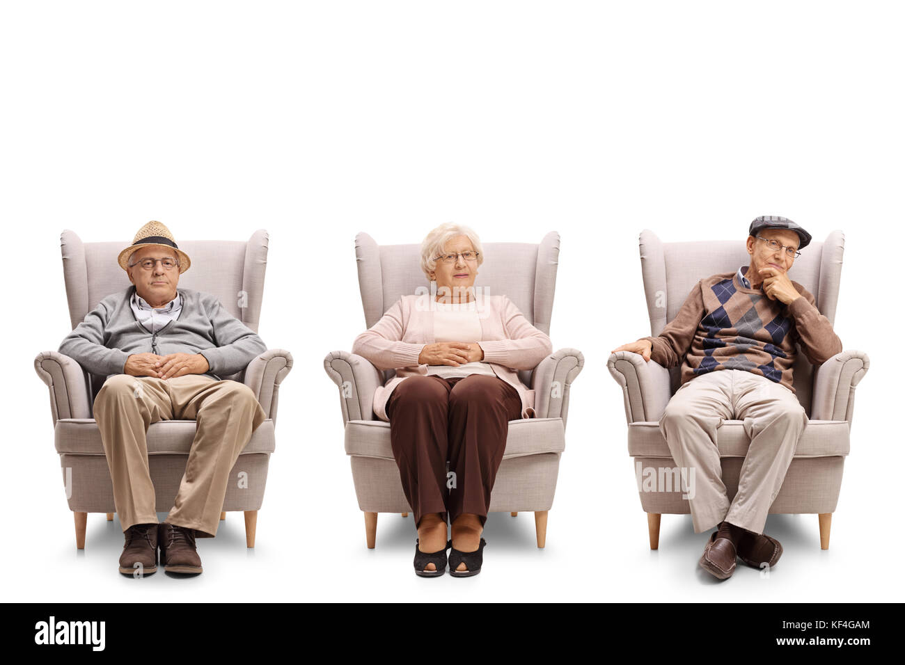 Gli anziani seduti in poltrona e guardando la telecamera isolata su sfondo bianco Foto Stock