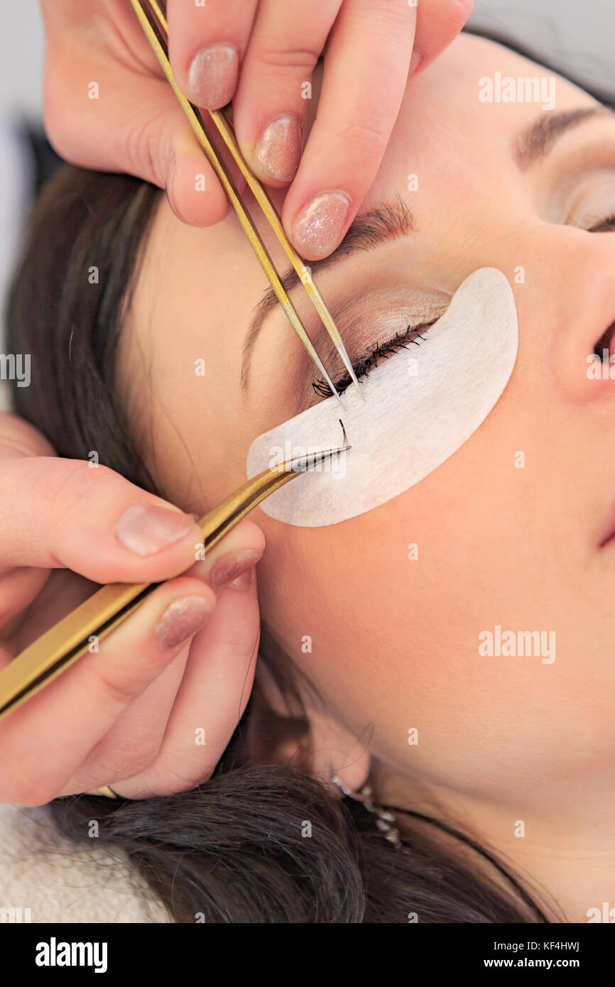 Primo piano di un volto femminile mediante la ricezione di allungamento delle ciglia presso il salone di bellezza Foto Stock