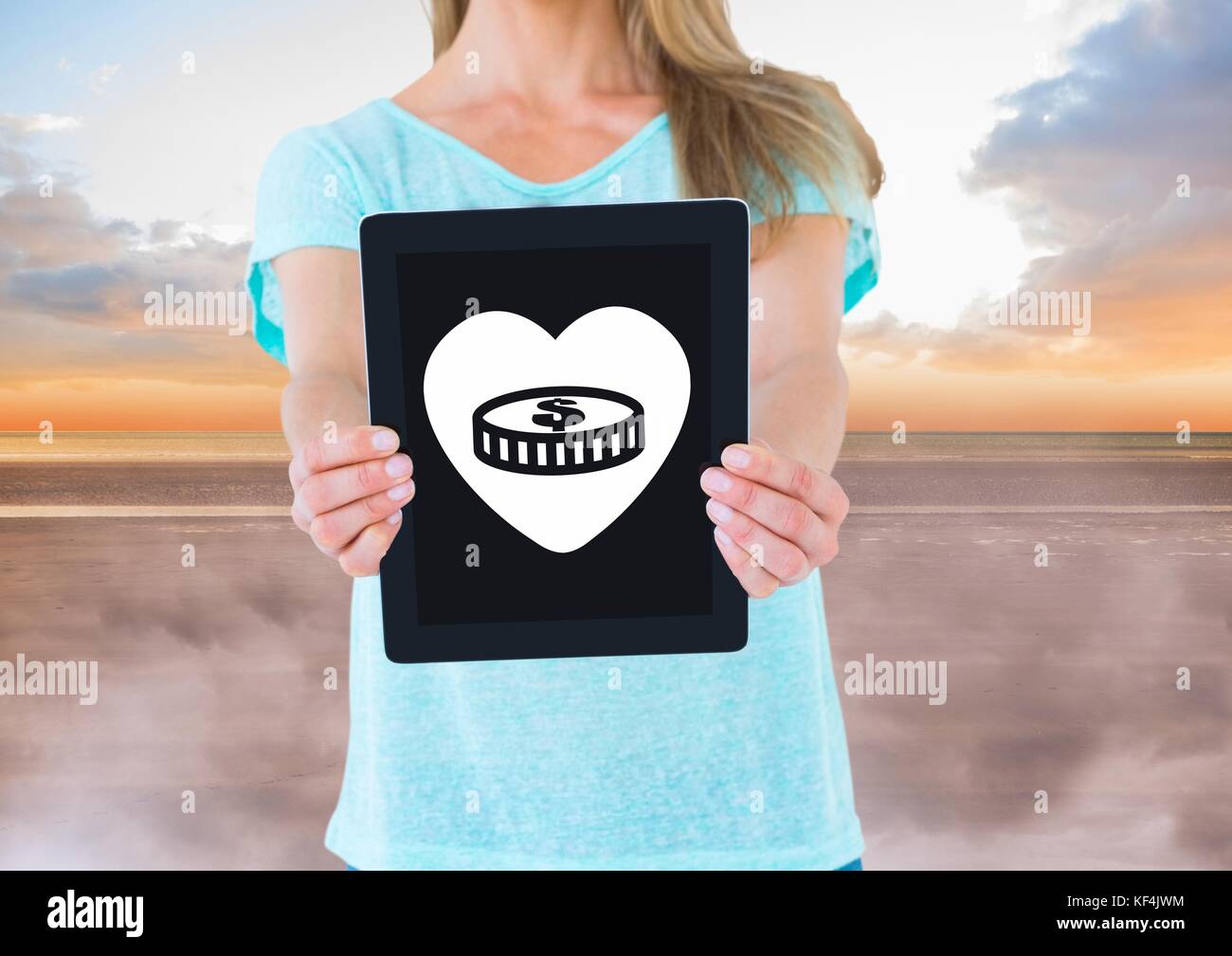 Composito Digitale della donna azienda tablet con denaro in Icona cuore Foto Stock