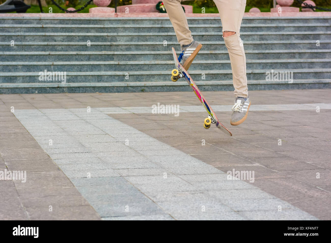 Parte inferiore del pattinatore teenager fare trucchi con lo skateboard all'aperto Foto Stock