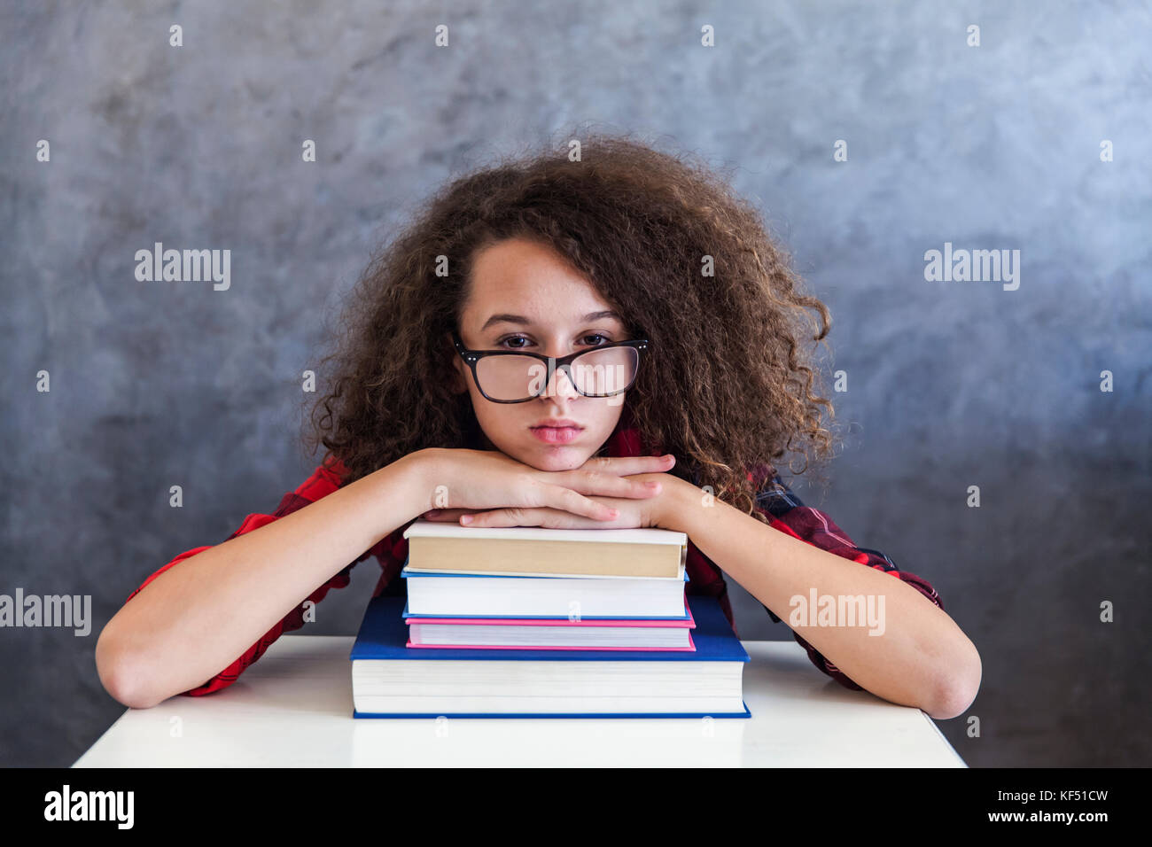 Ritratto di stanchi capelli ricci teen ragazza resto dall'apprendimento sui libri Foto Stock