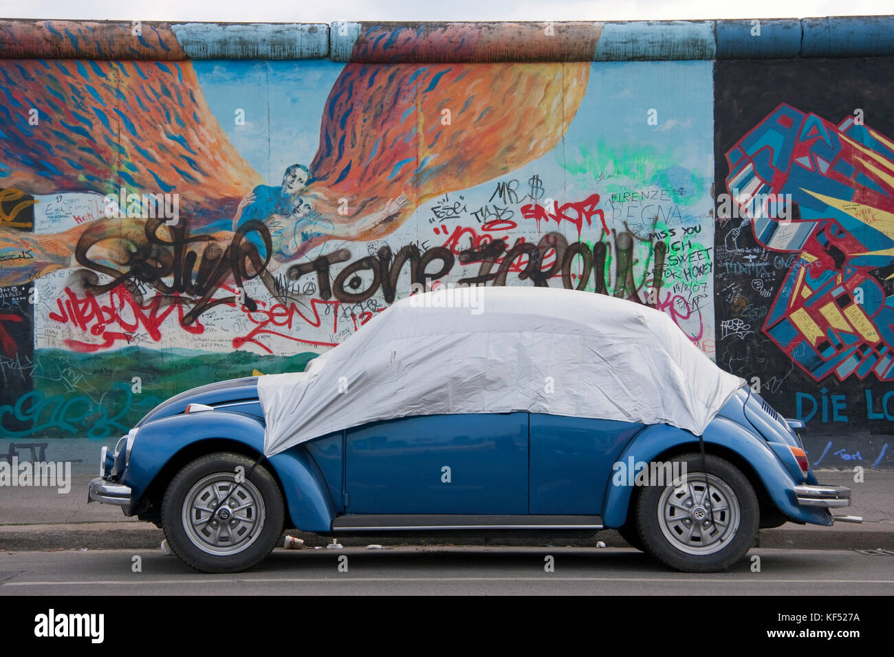 Germania Berlino, Friedrichshain, Galleria sul lato orientale " VW Beetle' sotto un telo. Foto Stock