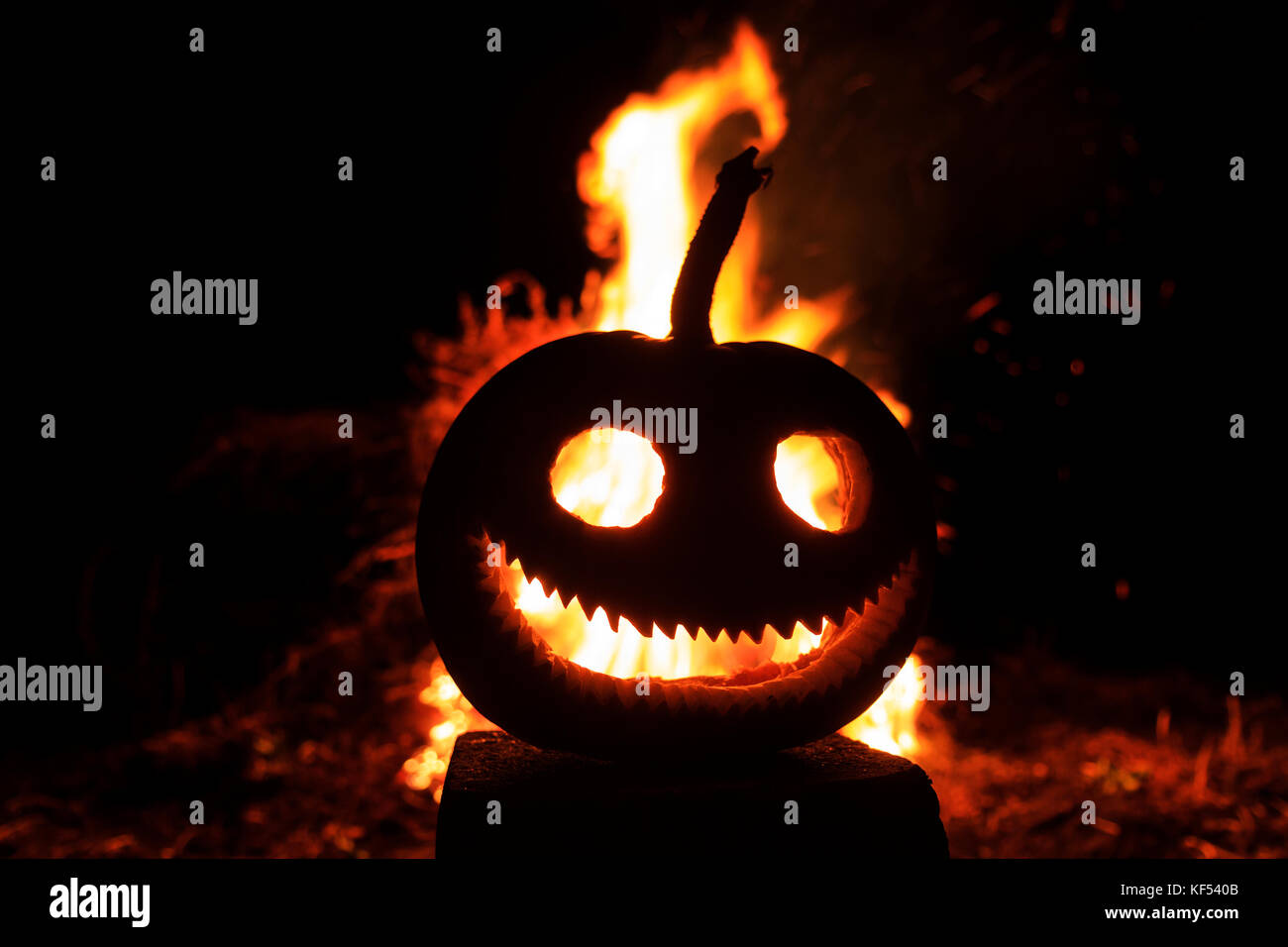 Testa di zucca con un sorriso terribile contro lo sfondo di fuoco Foto Stock