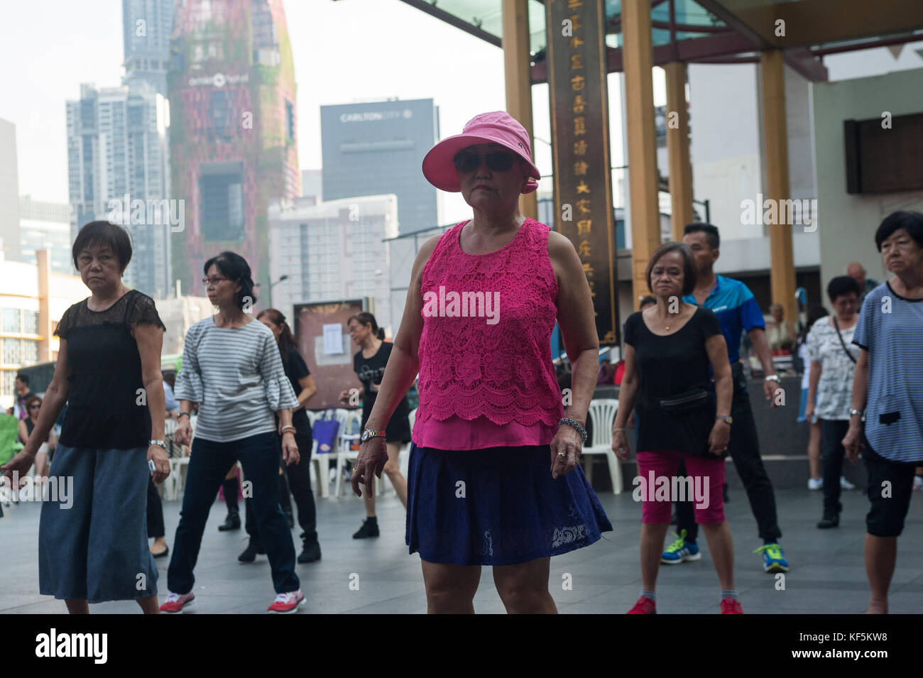 22.10.2017, Singapore, Repubblica di Singapore, Asia - Un gruppo di anziani si riunisce la domenica per ballare in fila in una piazza pubblica di Chinatown. Foto Stock