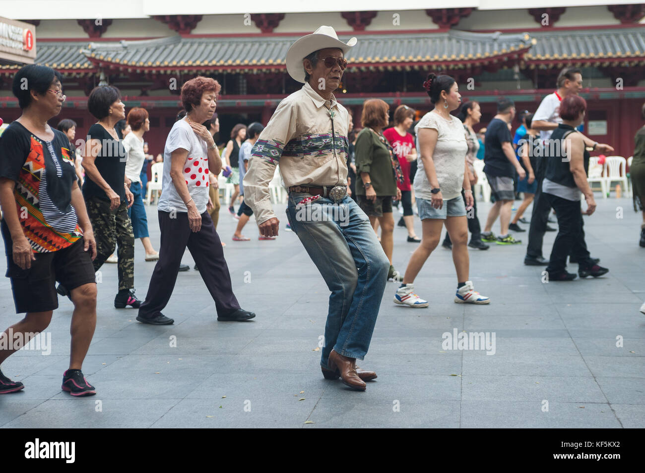 22.10.2017, Singapore, Repubblica di Singapore, Asia - Un gruppo di anziani si riunisce la domenica per ballare in fila in una piazza pubblica di Chinatown. Foto Stock