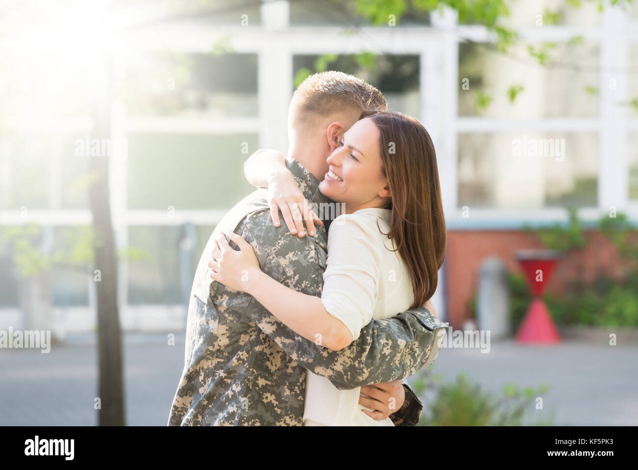 Ritratto di Felice moglie abbracciando il marito in uniforme militare Foto Stock