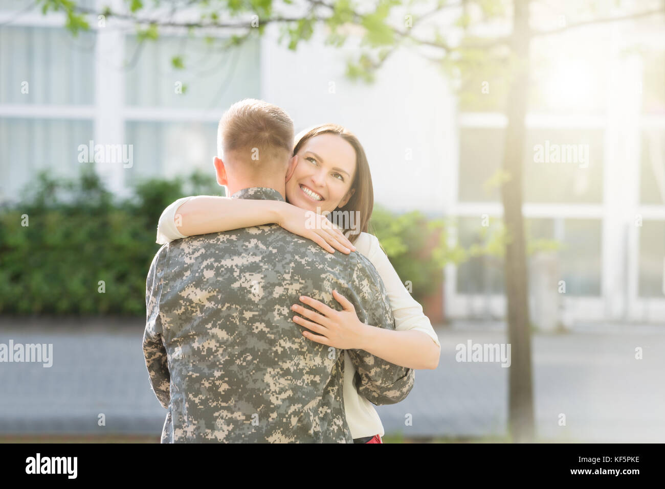 Ritratto di Felice moglie abbracciando il marito in uniforme militare Foto Stock