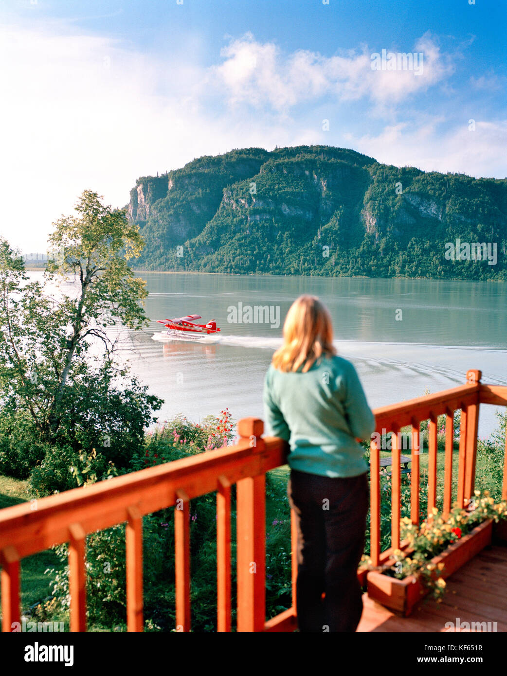 Stati Uniti d'America, Alaska, Donna Orologi un float plane a decollare in redoubt bay, redoubt bay lodge Foto Stock