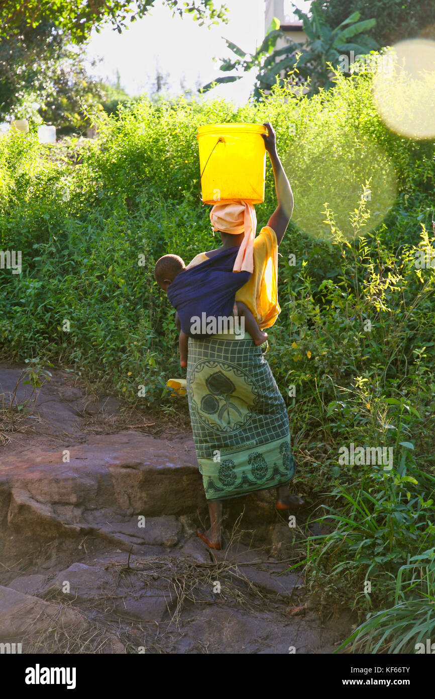 Vivere in Kenya Slum Aerias - Donna la raccolta di acqua potabile dalla sorgente Foto Stock