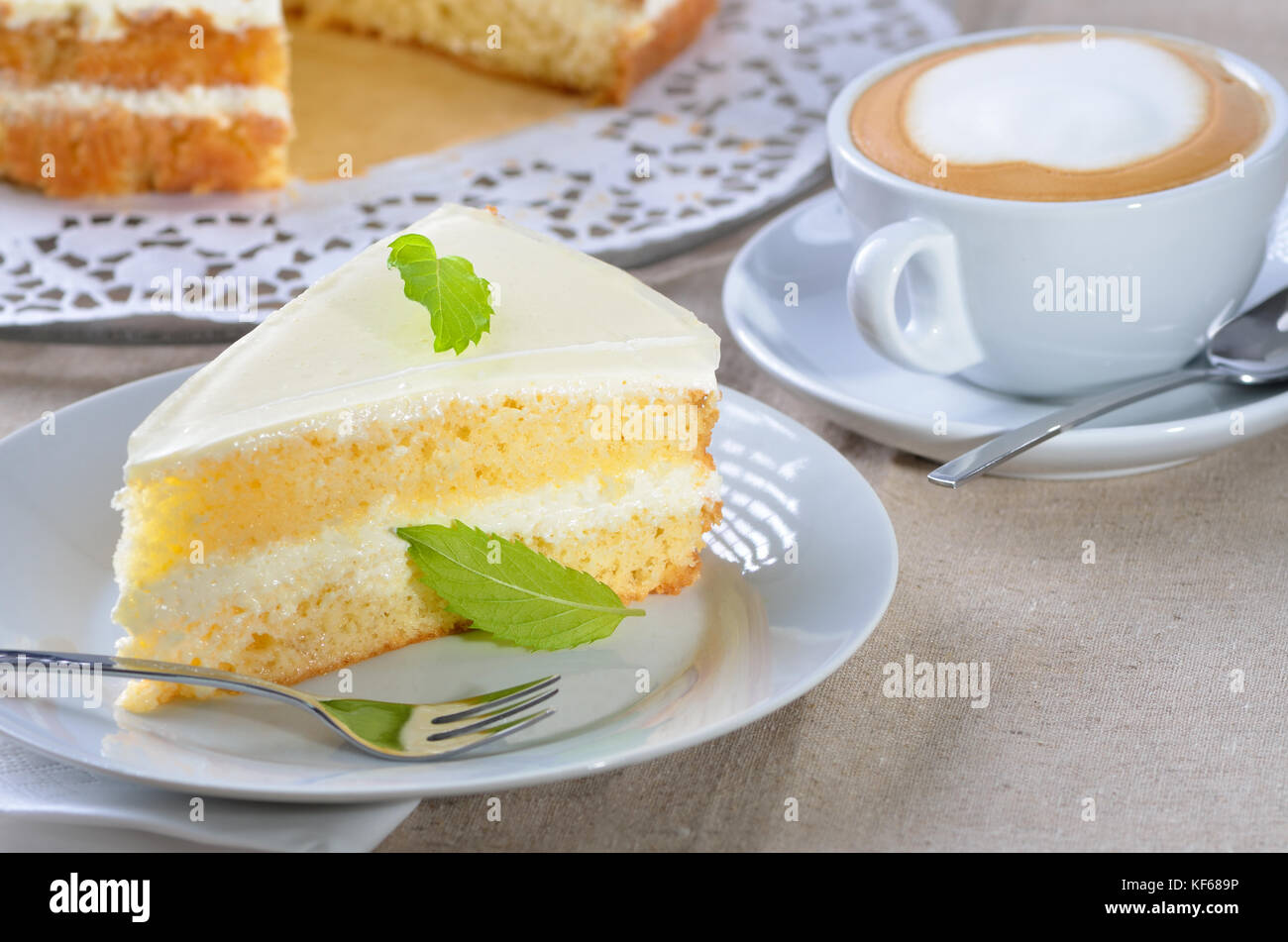 Voglia di torta con yogurt e crema di formaggio, servita con un cappuccino Foto Stock