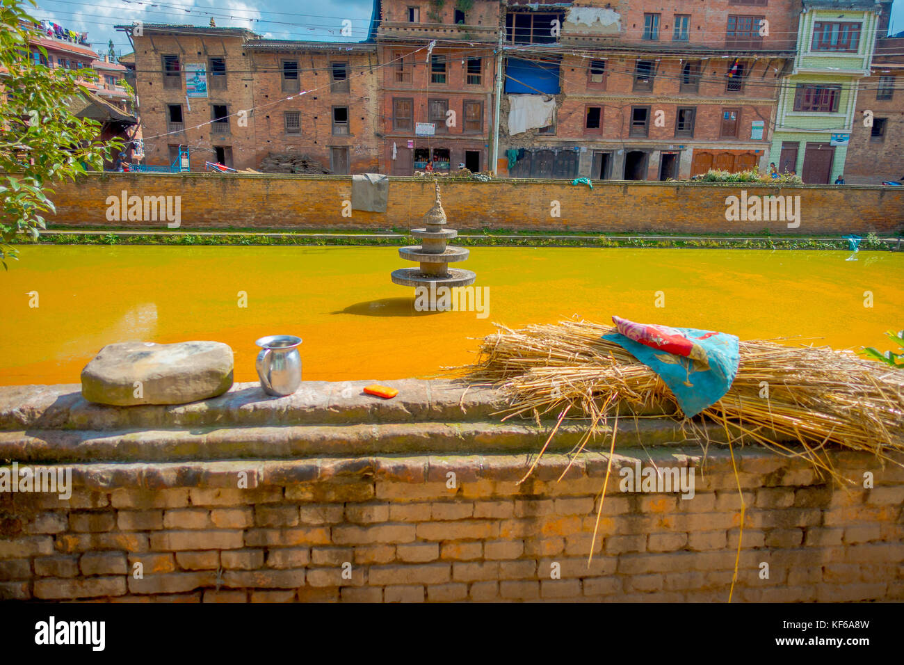 Bhaktapur, nepal - Novembre 04, 2017: close up dei tradizionali scena urbana con un laghetto artificiale di acqua gialla a bhaktapur city, Nepal Foto Stock