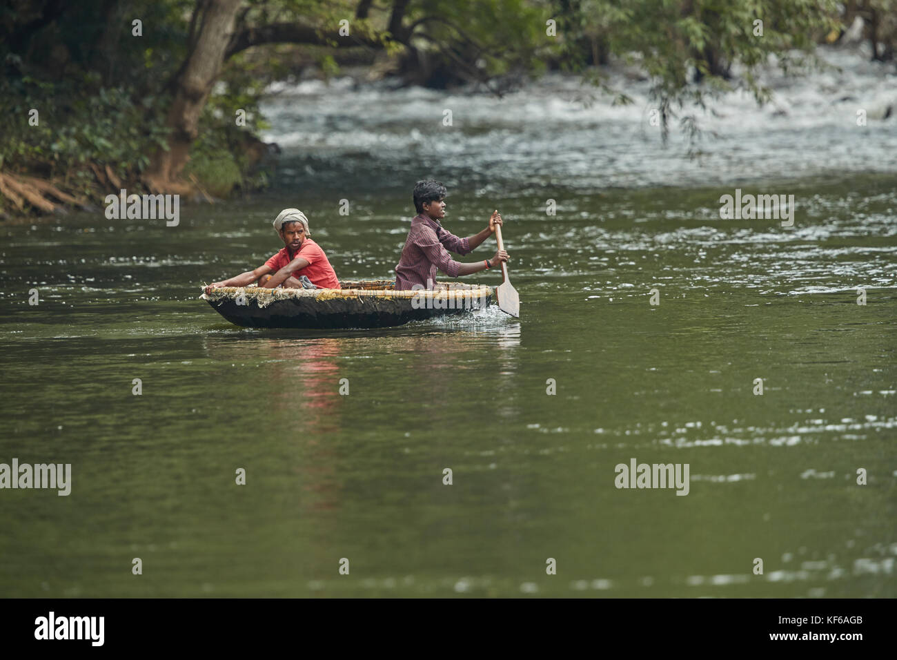 Trasporto in un rustico coracle rotondo canestro galleggiante barca fatta di bambù e plastica Foto Stock