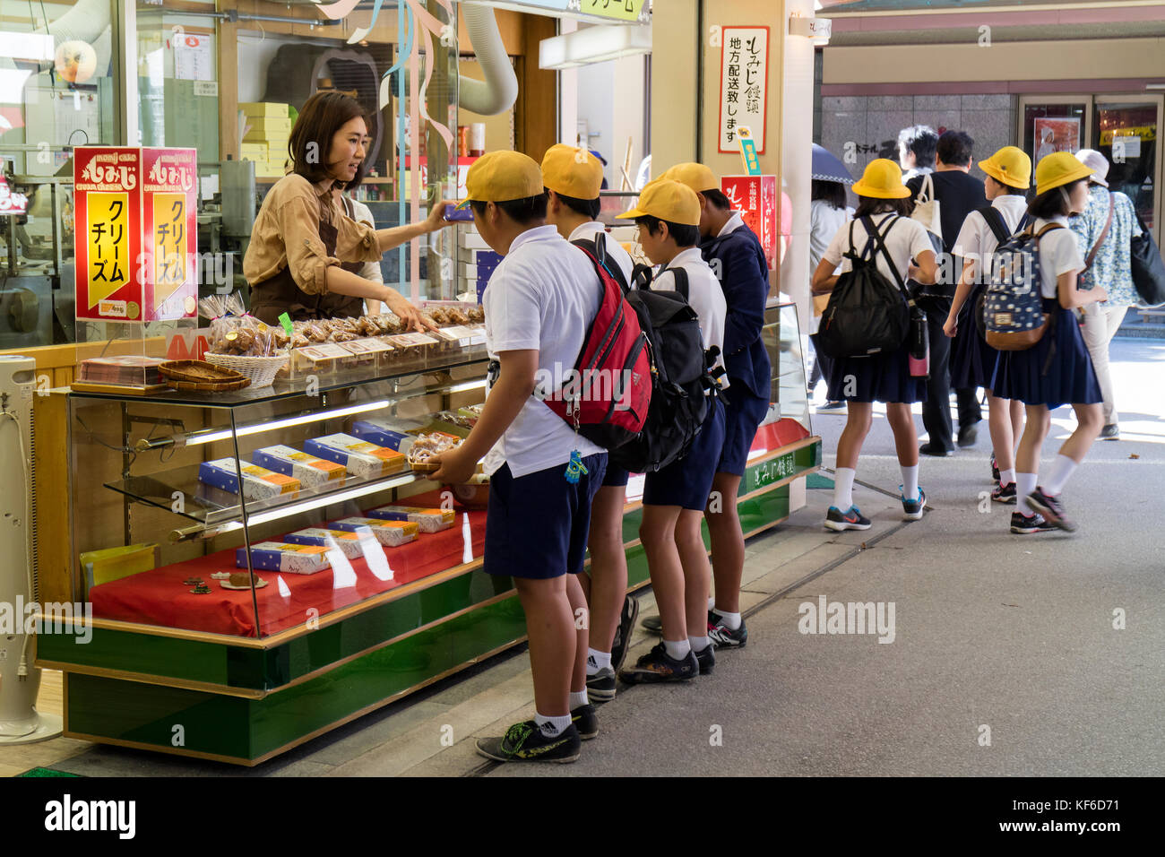 Miyajima, Giappone - 26 maggio 2017:gruppo di bambini delle scuole in uniforme acquisto di regali e dolciumi in miyajima in gita scolastica Foto Stock