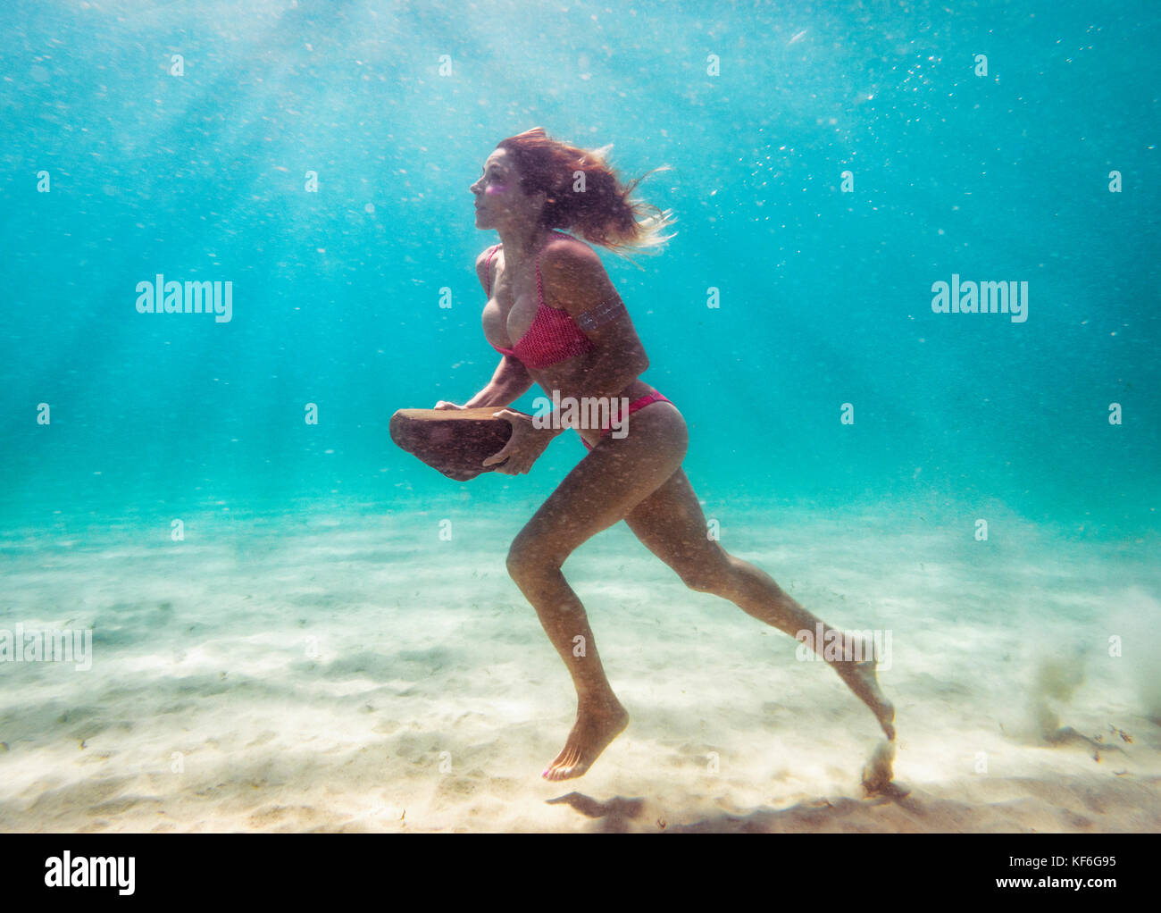 Montare donna formazione subacquei con una roccia Foto Stock