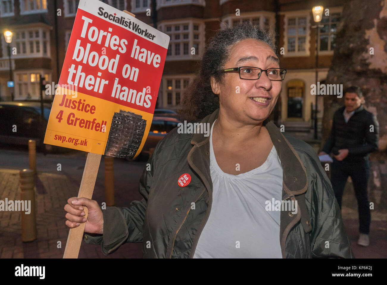 Londra, Regno Unito. 25 ott 2017. Un manifestante al di fuori del Royal Borough di Kensington & Chelsea riunione del Consiglio contiene una giustizia per Grenfell e targhetta era distribuire volantini contro la proposta di fusione di genesi e di Notting Hill Associazioni di alloggiamento. Altri protestando incluso guerra di classe che ha forti legami con la zona. Credito: Peter Marshall / Alamy Live News Foto Stock