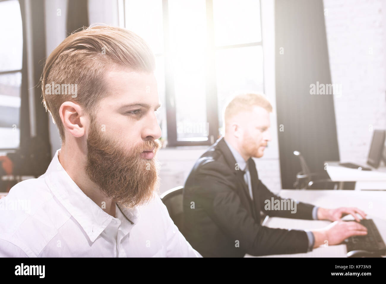 Uomo d'affari dell'ufficio a lavorare con un computer con il suo team Foto Stock