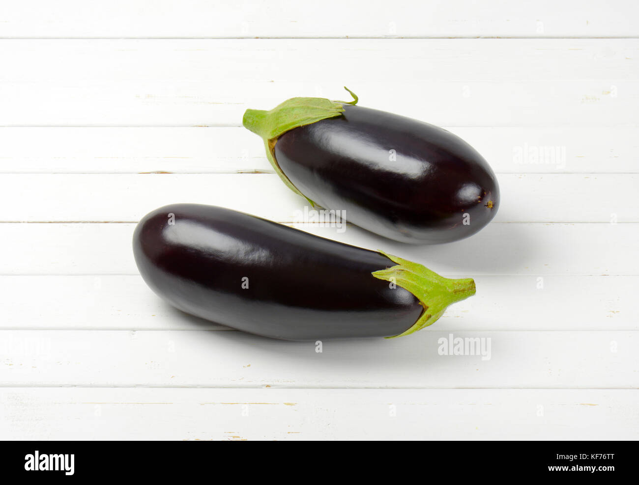 Due melanzane fresco bianco su sfondo di legno Foto Stock