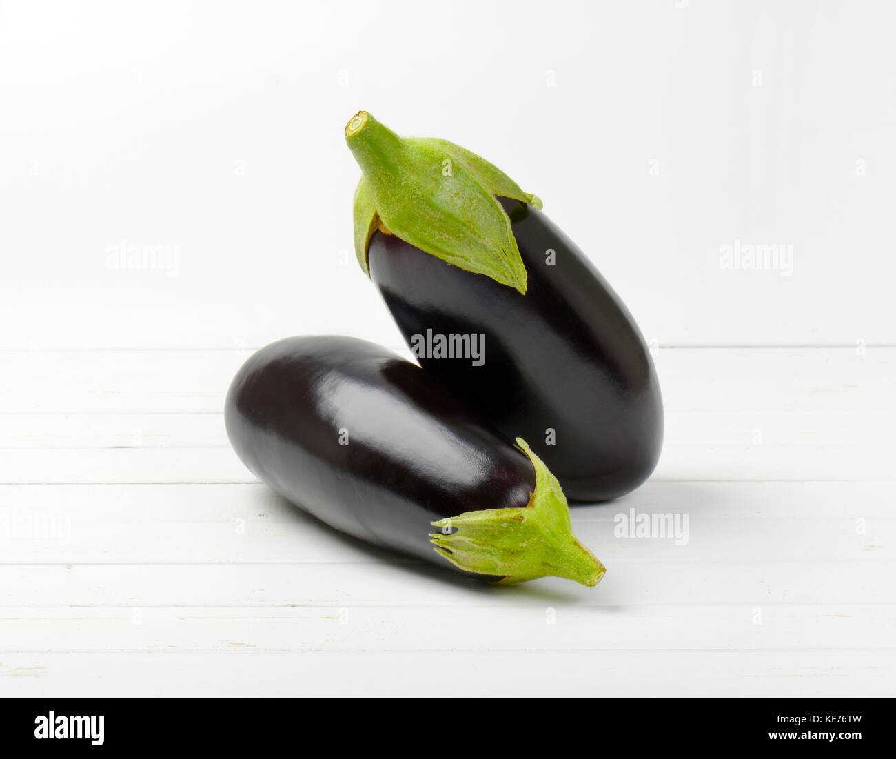 Due melanzane fresco bianco su sfondo di legno Foto Stock