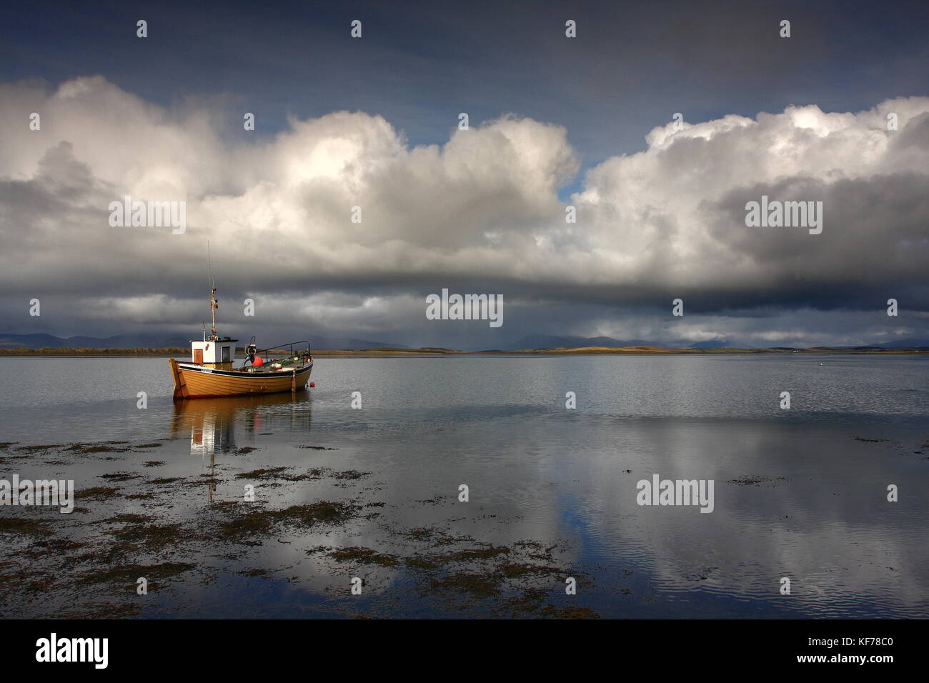 Vista panoramica dell'Oceano Atlantico oltre il cielo nuvoloso nella Baia di Clew Westport Irlanda County Mayo. Giallo riflessione in barca con vista mare e colline in lontananza. Foto Stock