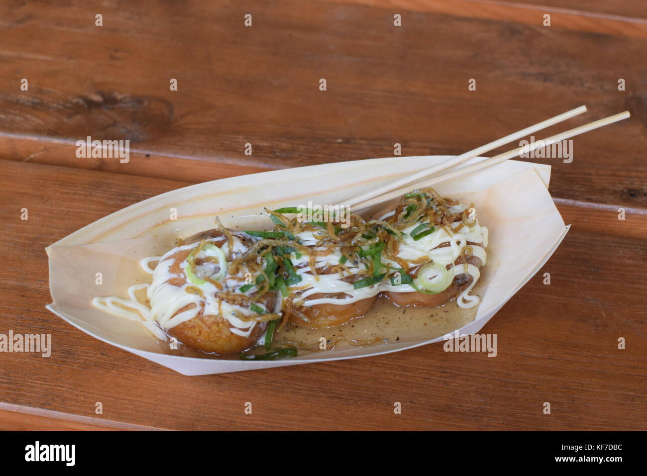 Una porzione di takoyaki giapponese, una tipica merenda a base di frumento a base di farina di pastella con pezzi di polpo all'interno Foto Stock