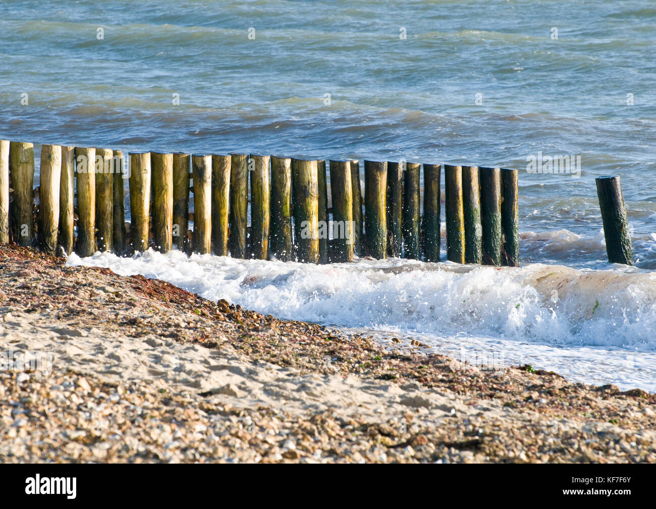 Un colpo di le onde che si infrangono contro alcuni pennelli a Lepe beach, Hampshire, Inghilterra. Foto Stock
