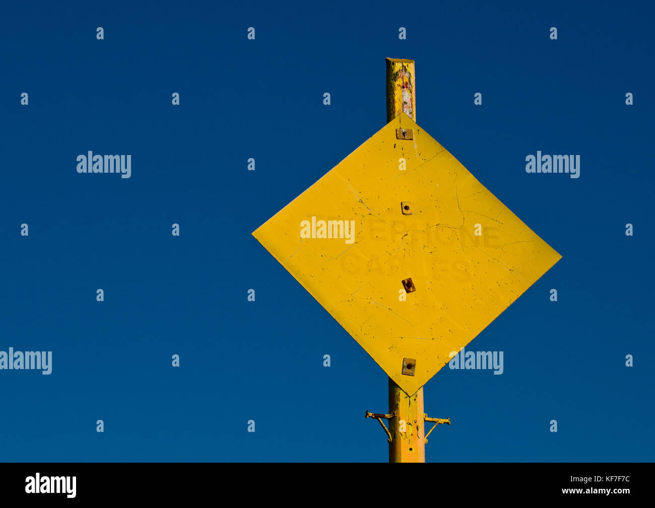 Un colpo di un segno giallo contro un cielo blu con le parole i cavi telefonici scritto su di esso. Foto Stock