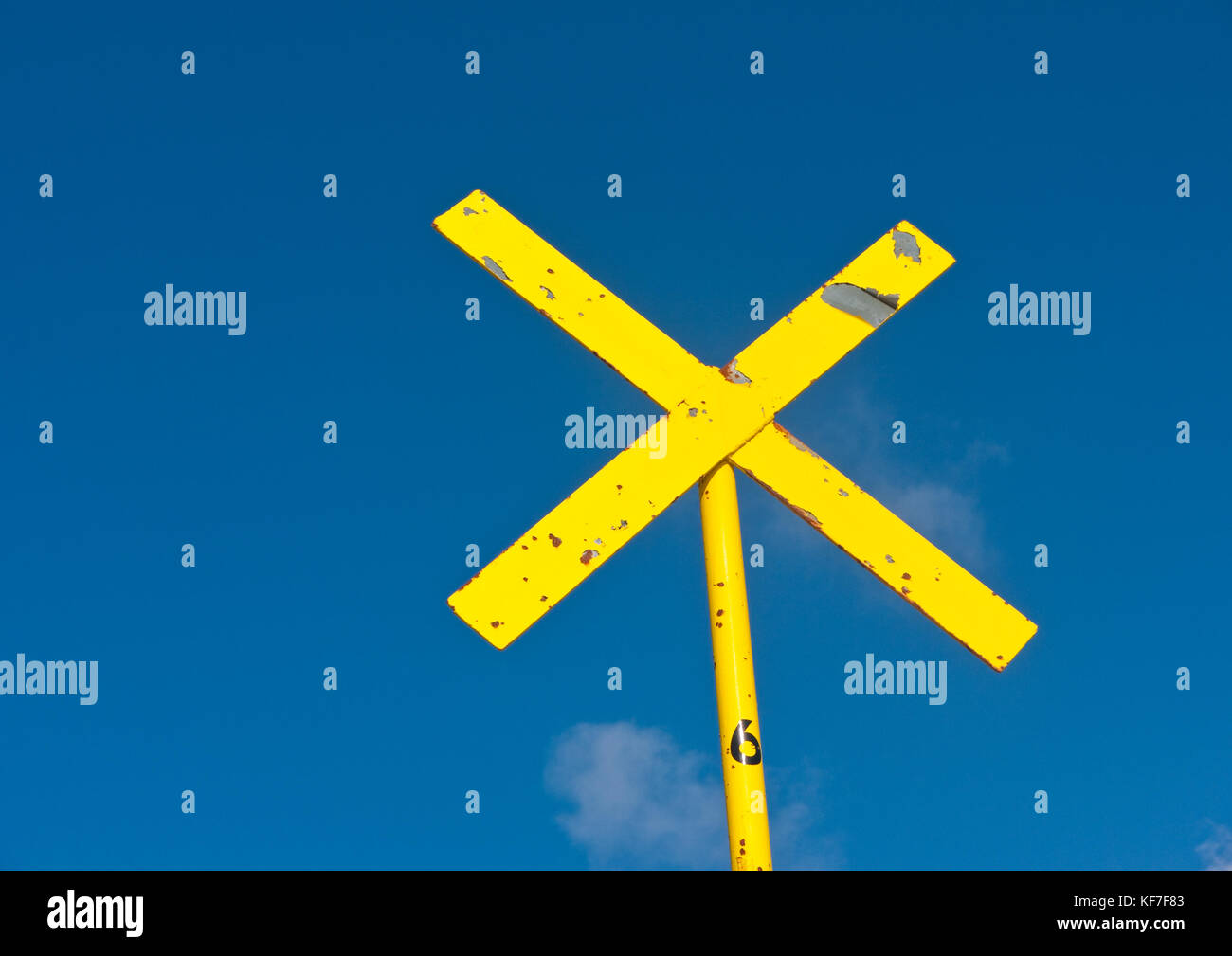 Un colpo di un giallo x signpost contro un cielo blu. Foto Stock