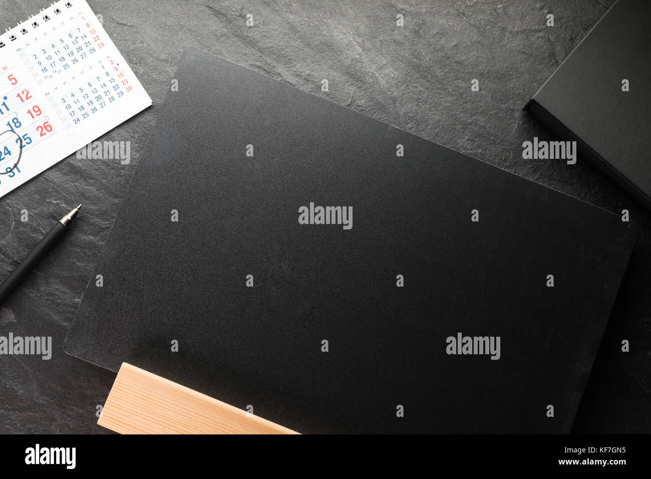 Scheda per iscrizioni e penna, calendario su una pietra grigia orizzontale Foto Stock