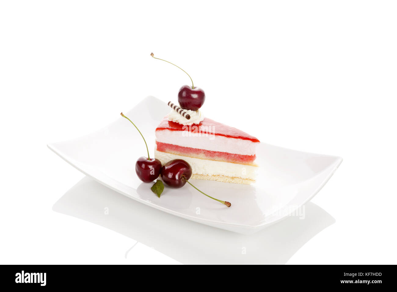 Deliziosa ciliegio dolce torta con ciliegie sulla piastra bianca. isolato su sfondo bianco con la riflessione. dessert. Foto Stock