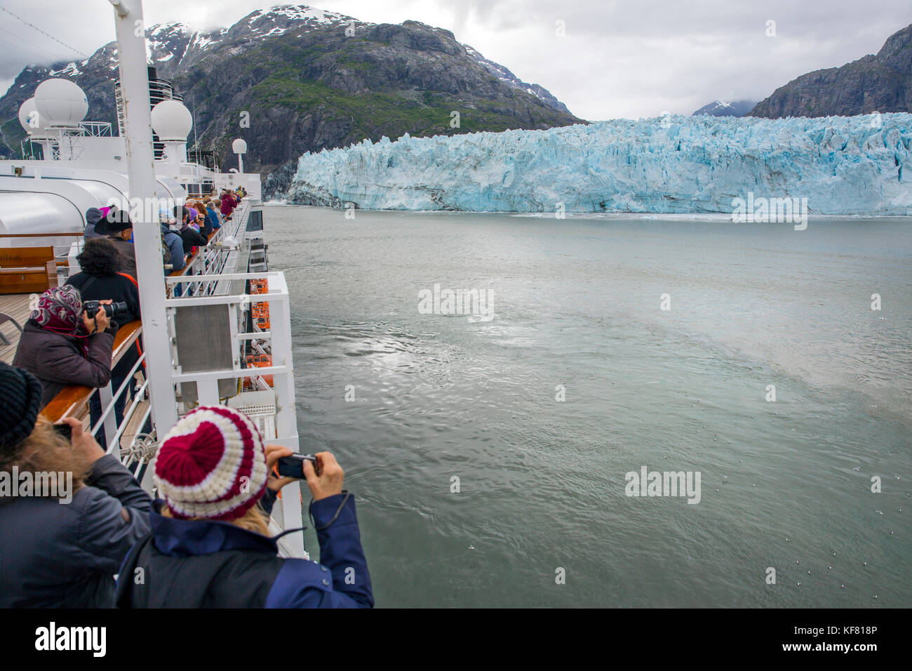 Stati Uniti d'America, Alaska Glacier Bay, passeggeri testa a prua della barca per ottenere una vista migliore della grand pacific glacier fino tarr ingresso, mentre a bordo della CRU Foto Stock